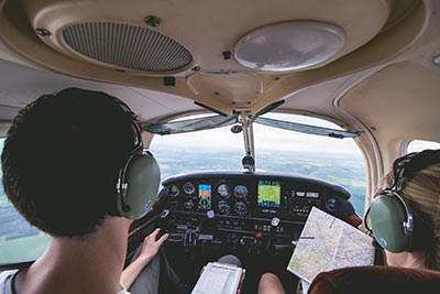 Female and male pilots are cooperating during flight on a small aircraft
