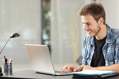 Entrepreneur or student man working or studying using a laptop on a desk at home