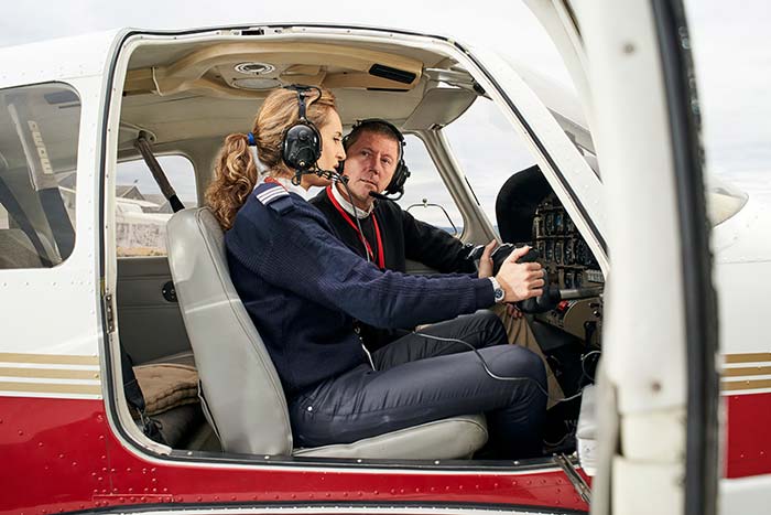 Pilot in training and flight instructor in the cockpit of an airplane