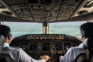 Inside cockpit of commercial airplane while fly approaching the runway. Outside window can see beautiful light from airport and inside cockpit can see
